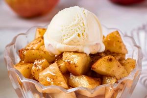 Microwave Baked Apples in a Glass Dish with a Scoop of Vanilla Ice Cream