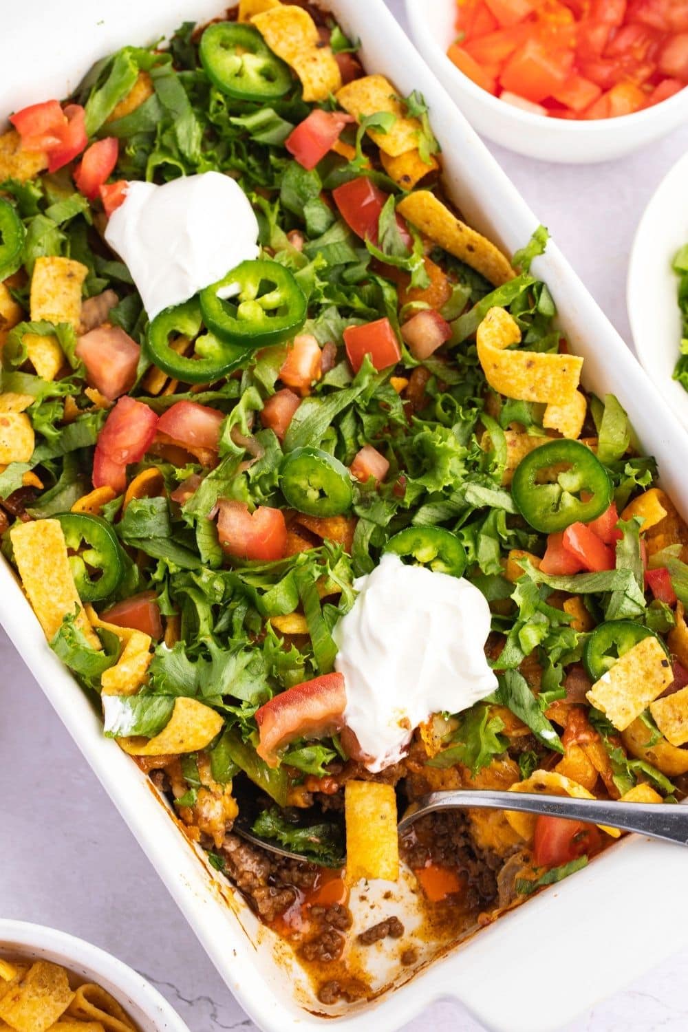 Homemade Walking Taco Casserole with Frito Chips, Ground Beef, Vegetables and Whipped Cream