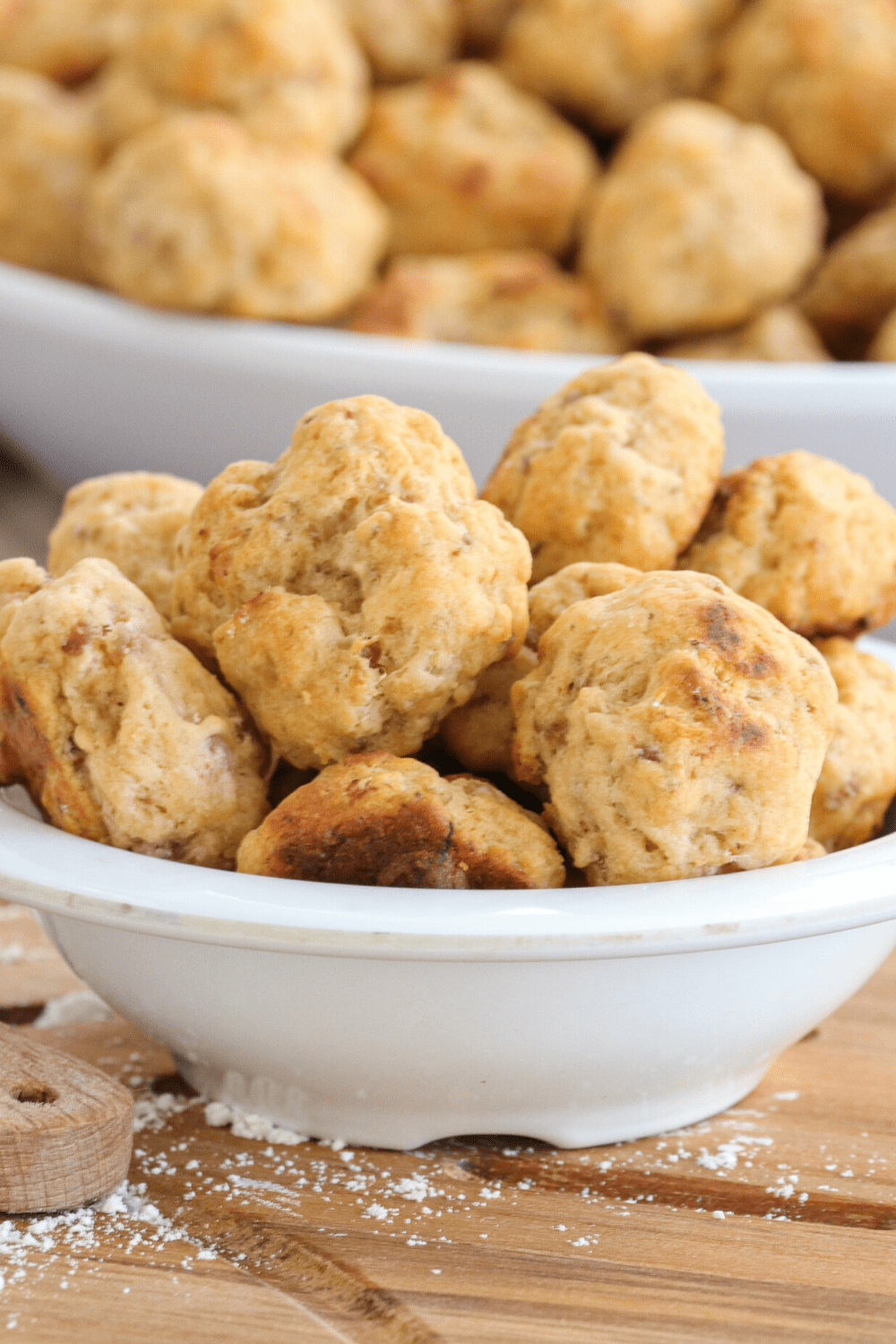 Bunch of sausage balls made with ground pork sausage, cheddar cheese, Bisquick baking mix, milk and dried chives served on a bowl 