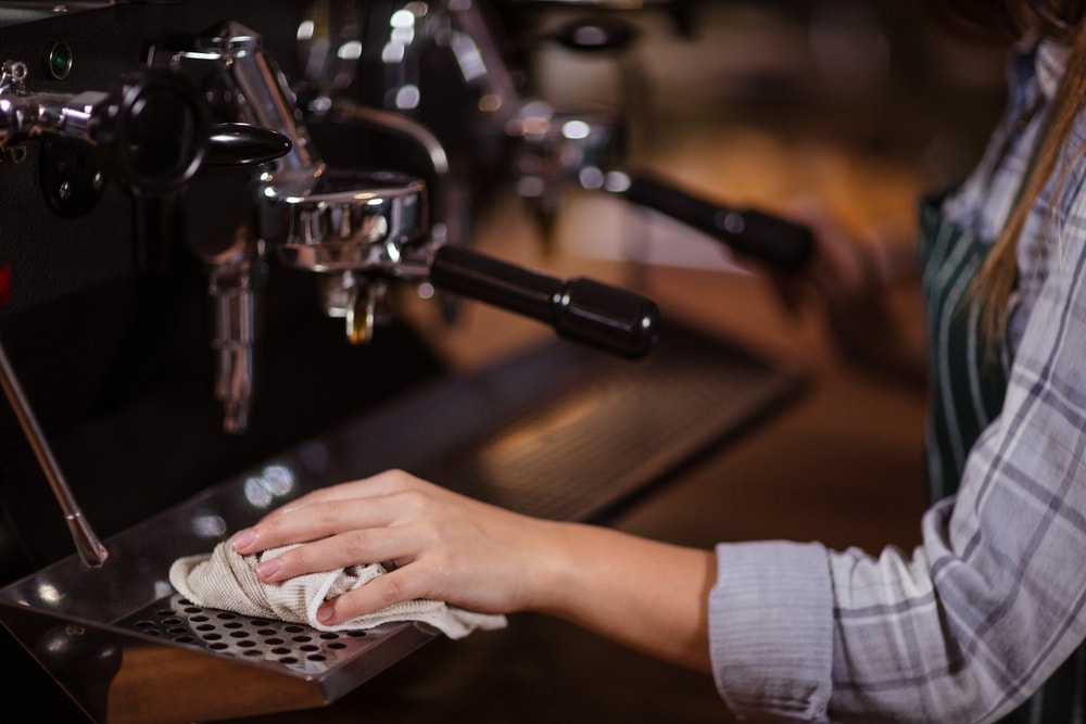 Barista Cleaning the Coffee Machine