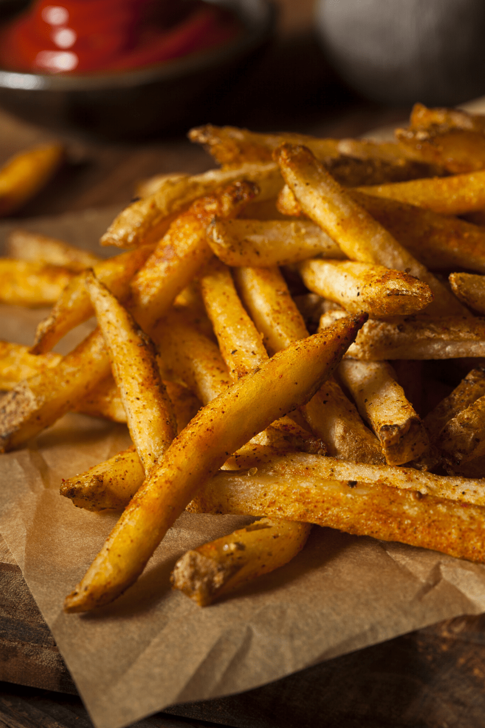 Bunch of fries on a brown parchment paper.