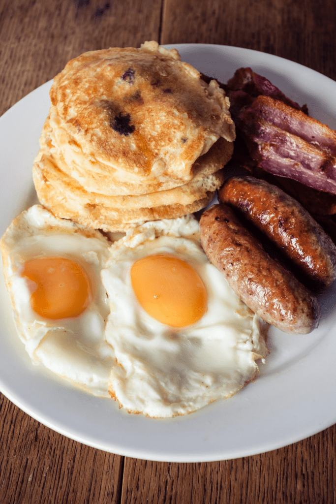 Pancakes with Fried Eggs, Bacon and Sausage for Breakfast