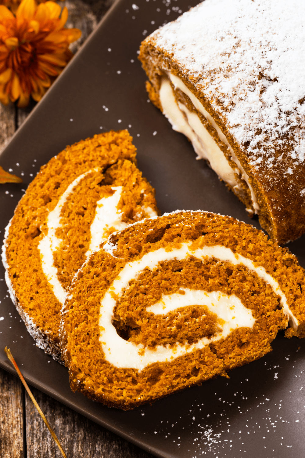 Slice of Homemade Pumpkin Roll served on a brown plate. 
