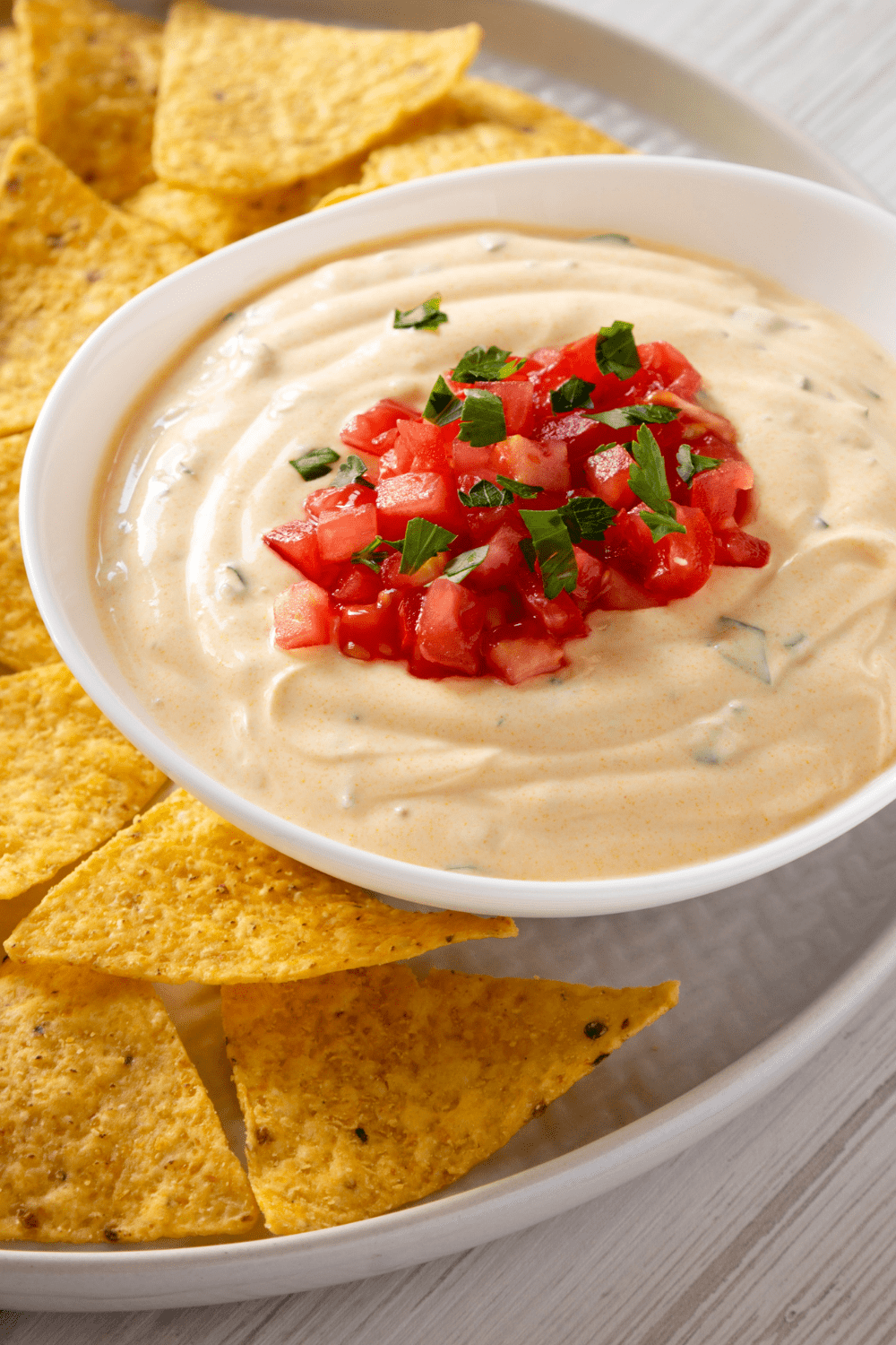 Homemade Queso Dip with nacho chips on a plate