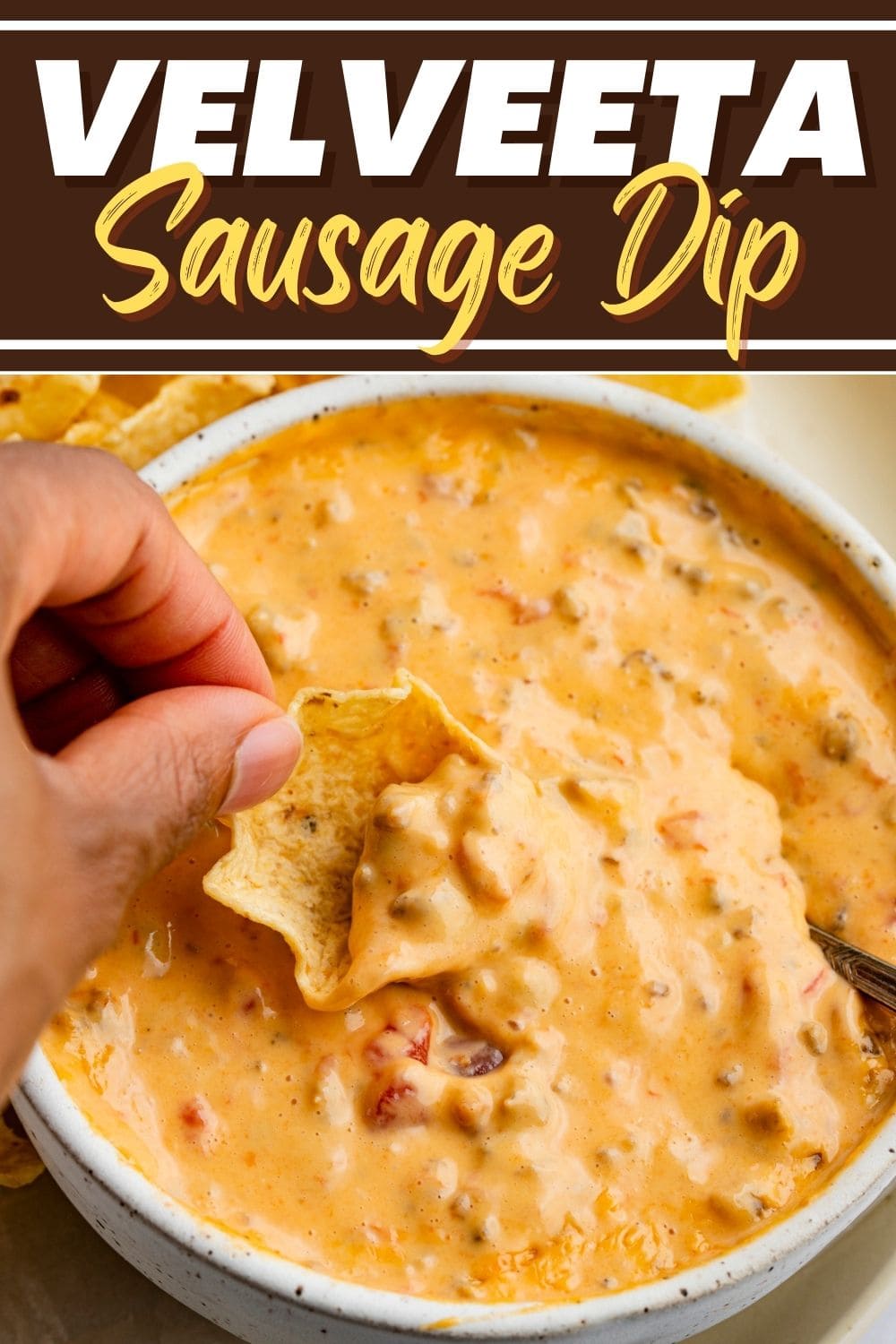 Chips dipped into a bowl of cheesy Velveeta Sausage Dip