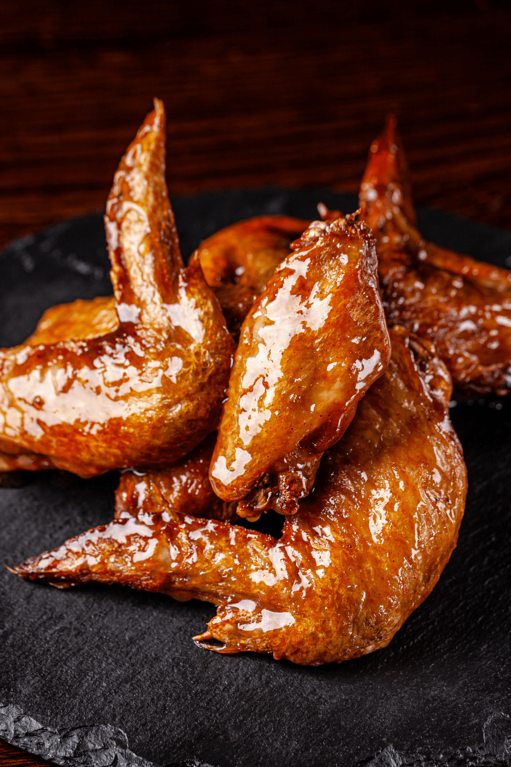 Chicken wings coated with sticky and glistening sauce. 