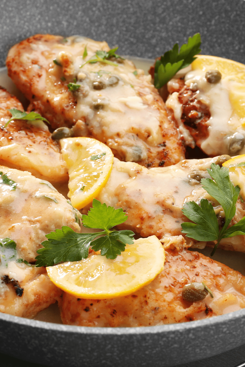 Homemade Chicken Piccata garnished with slice lemons and parsley