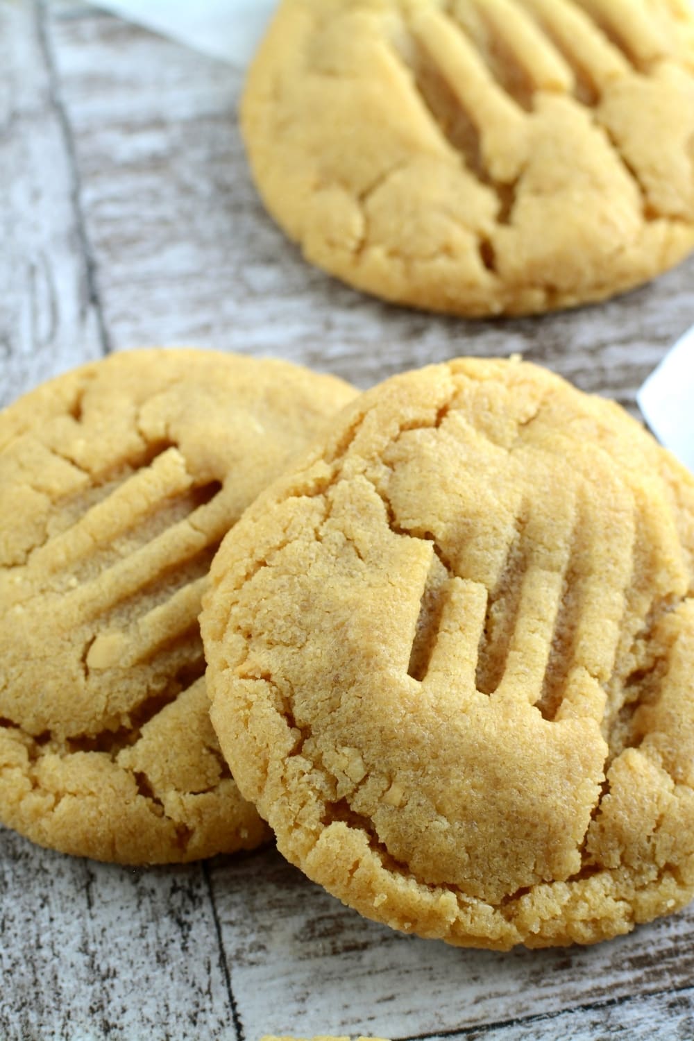 Bunch of peanut butter cookies on a wooden table.