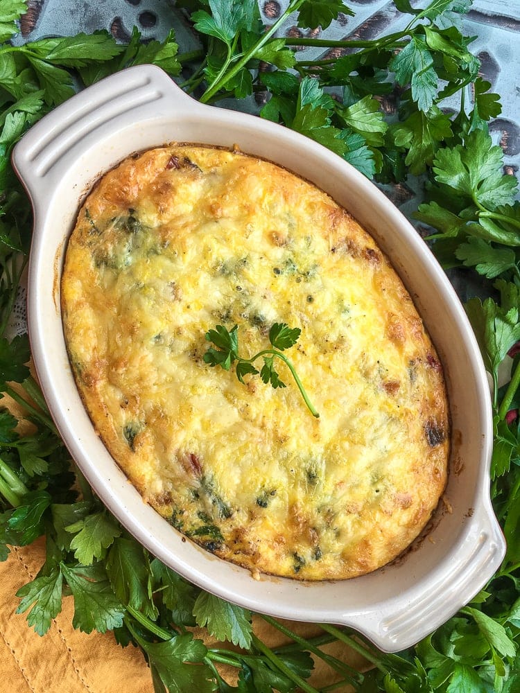 Potato frittata onions, peppers, spinach, and Gouda cheese on a caking dish.