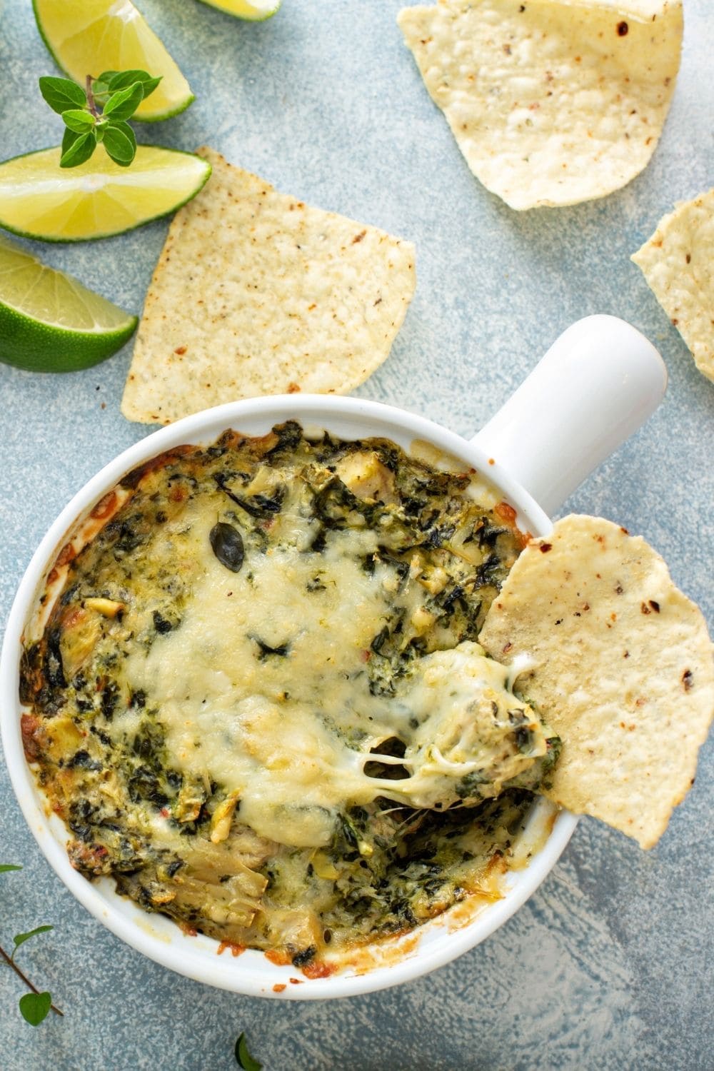 Tortilla dipped in a bowl of spinach artichoke dip 