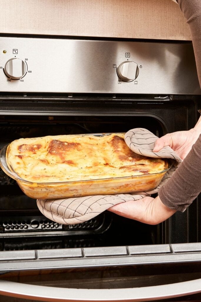 Woman Holding a Lasagna in the Oven