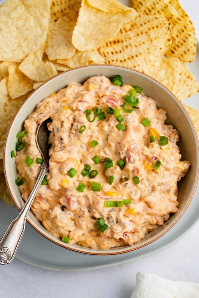 Bowl of Cheesy Cowboy Crack Dip with Corn, Onions and Chips