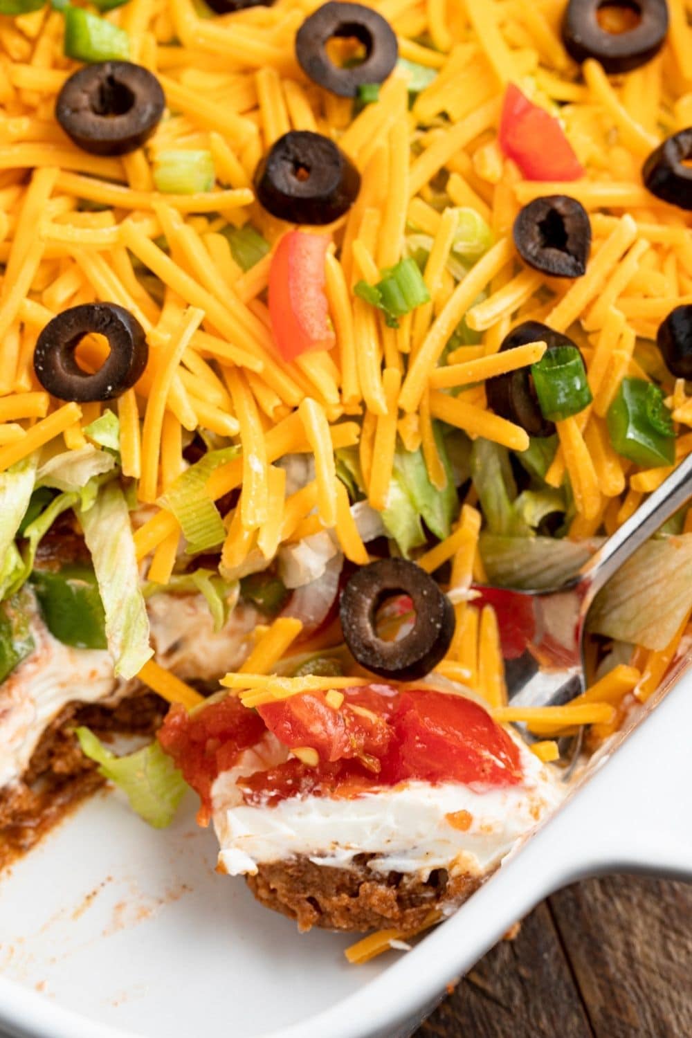 Homemade Cheesy Seven Layer Taco Dip with Black Olives, Tomatoes and Onions