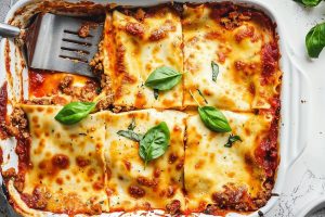 Top View of Prego Lasagna in a Casserole Dish, One Square Missing, and a Spatula