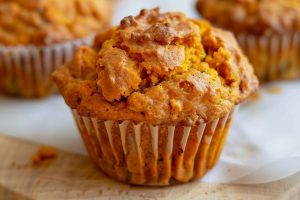 Close Up of Two-Ingredient Pumpkin Muffins on a Wooden Cutting Board with Parchment Paper