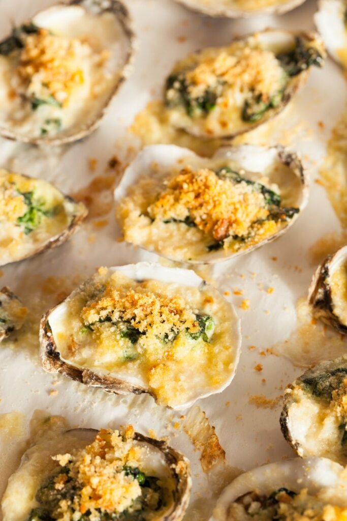 25 Best Oyster Recipes for an Easy Gourmet Dinner. Photo shows Creamy Buttered Oysters with Spinach and golden breadcrumbs on a platter