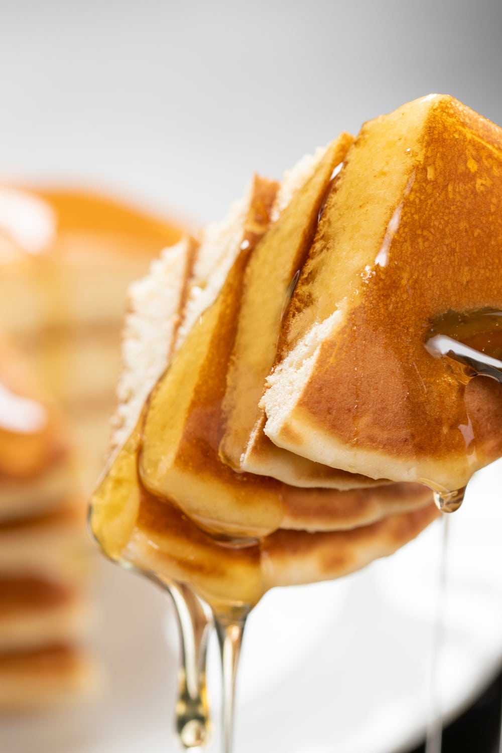 Sliced Flapjacks on a fork with maple syrup