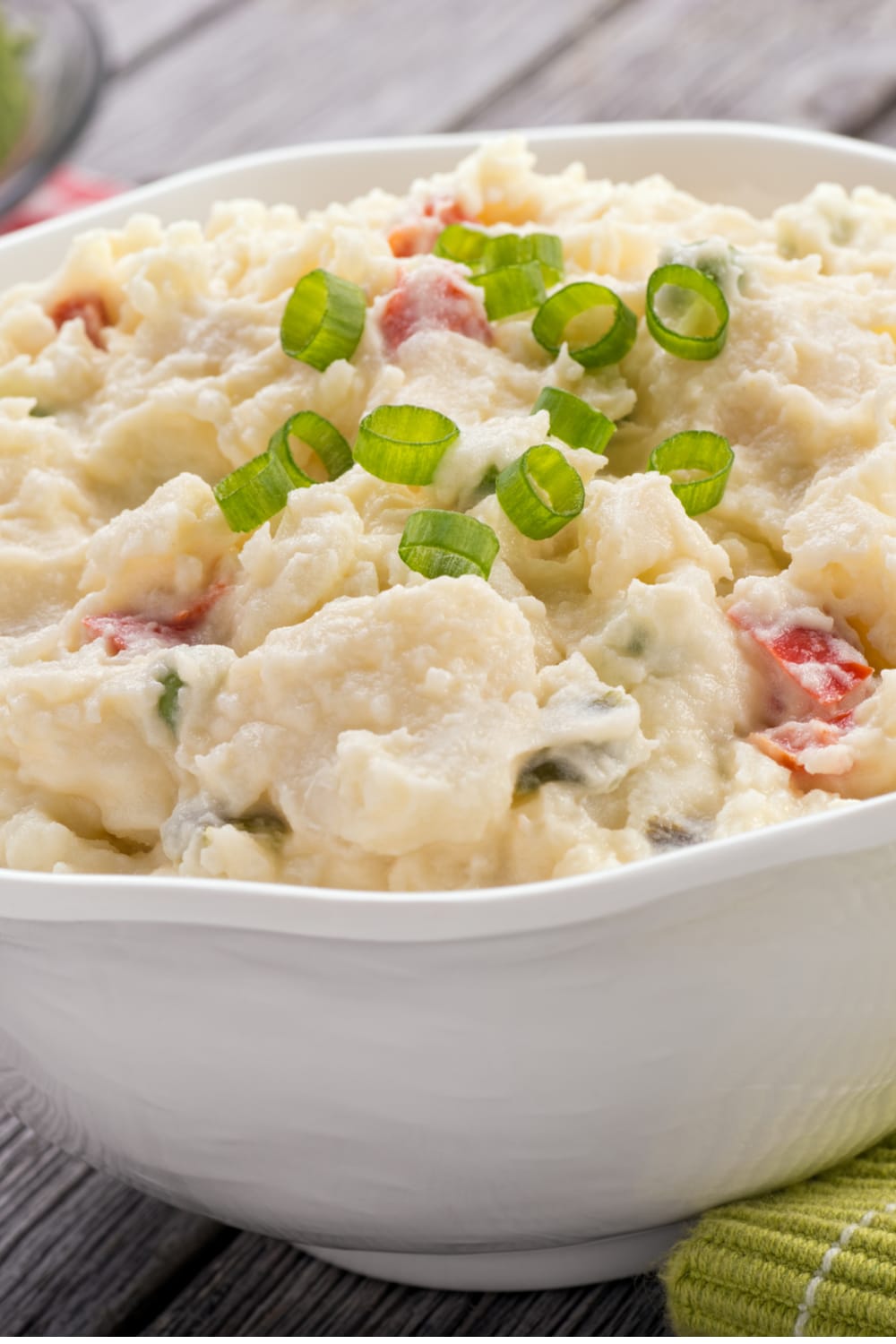 Bowl of Potato Salad with egg and mayonnaise, garnished with chopped green onions
