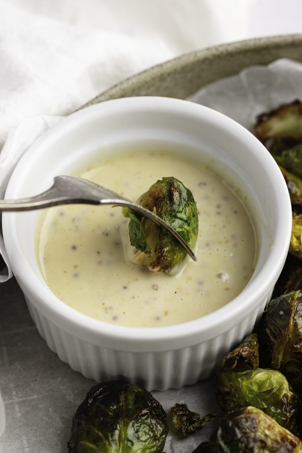 Air Fryer Brussels Sprouts dipped on white sauce.