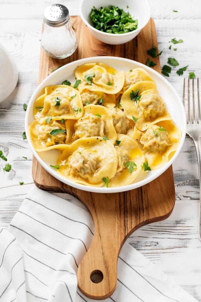 Ravioli Filling Ideas featuring Crab Stuffed Ravioli served in a white bowl with fresh herbs