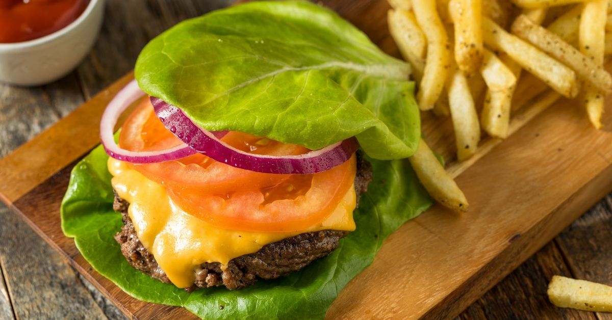 Keto Burger Wrapped In Lettuce Buns with Cheese, Tomatoes and Onions