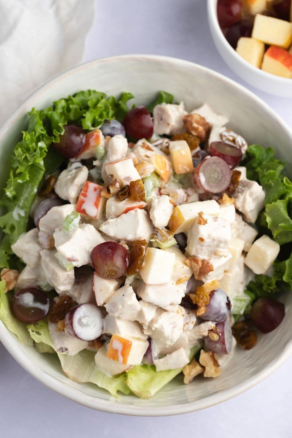 Salad mix with apples, grapes, raisins, walnuts and lettuce served on a bowl