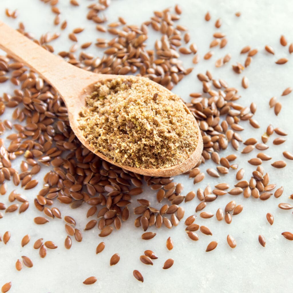 Ground Flax Seeds on a table with whole flax seeds