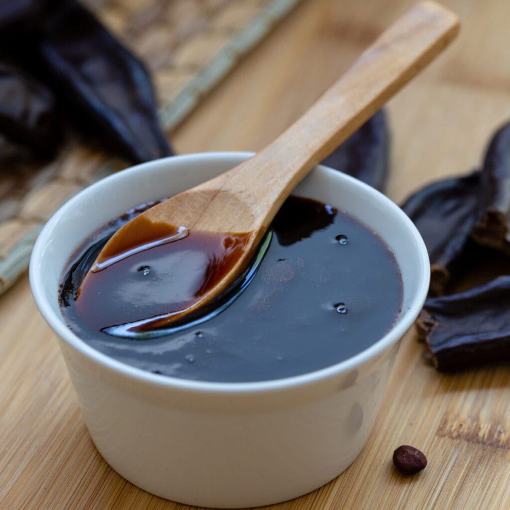 Molasses in a bowl with a wooden spoon