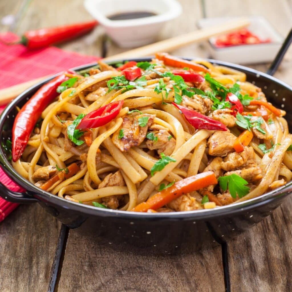 Chow Mein on a Skillet Topped With Vegetables and Chicken Meat