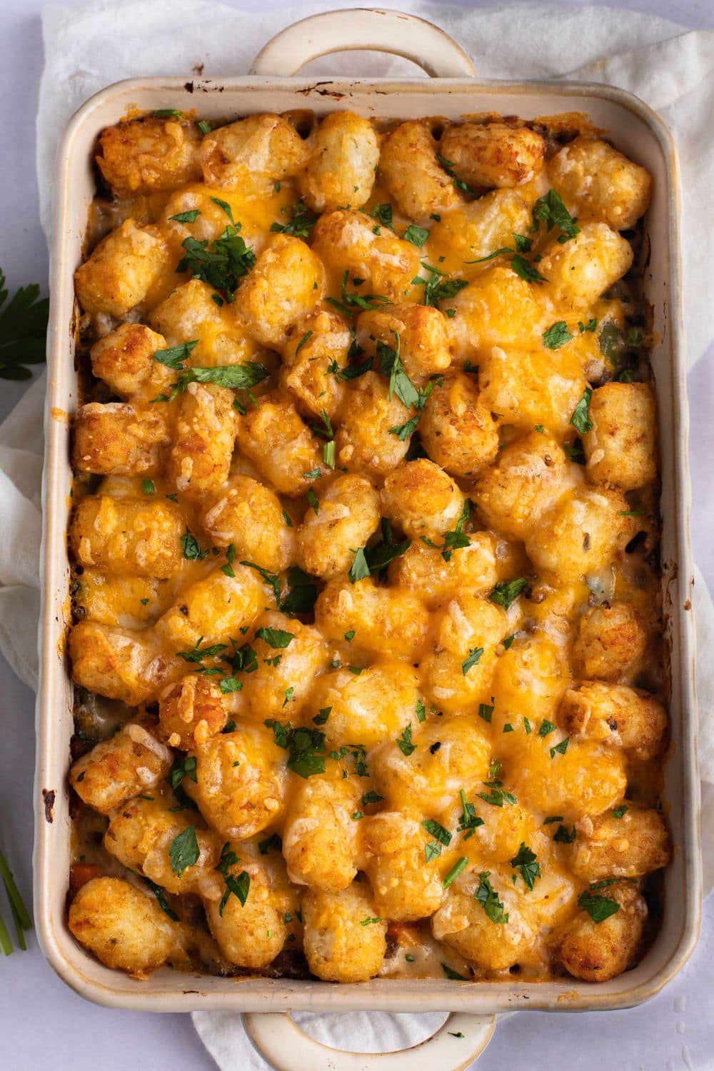 Top view of tater tot ground beef casserole on a white baking dish.