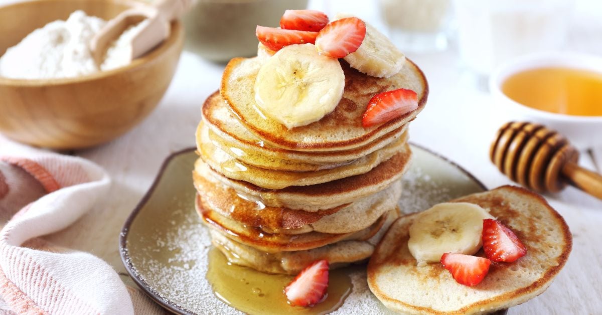 Homemade Banana Pancakes with Strawberries, Banana Slices and Honey