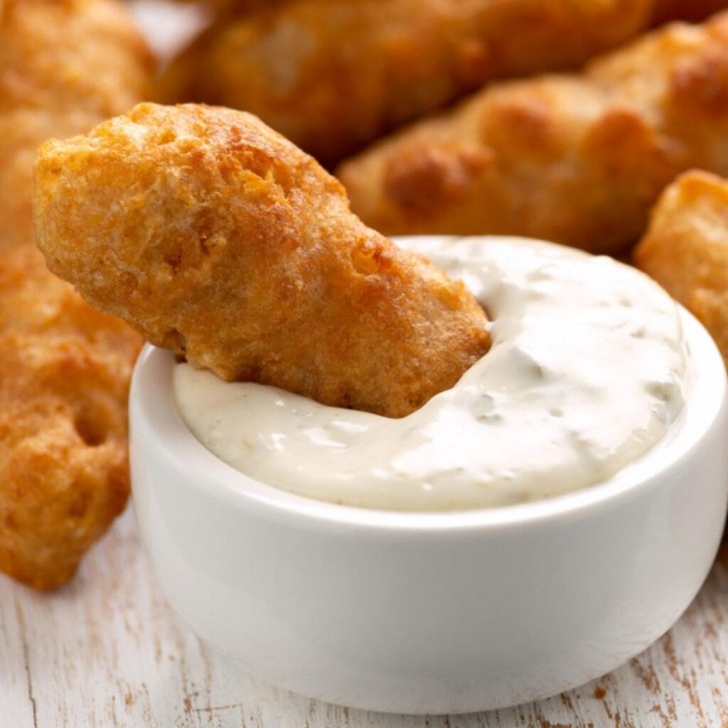 Fried Fish Fingers Dipped in a bowl of Creamy Tartar Sauce