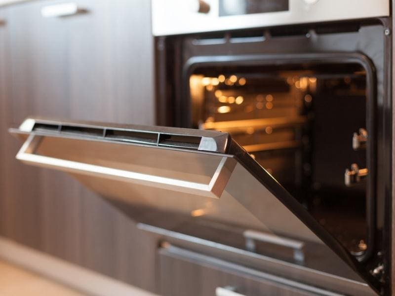 An Oven With Door Halfway Opened