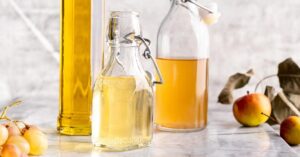 Glass Bottles of White Wine Vinegar in a Marble Table