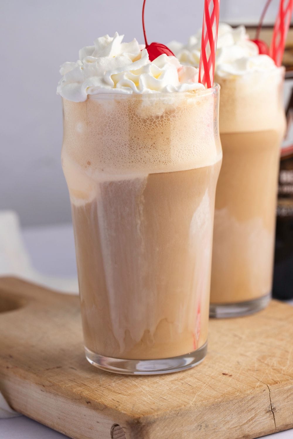 Glasses of Homemade Root Beer Float with Whipped Cream, Ice Cream and Cherries