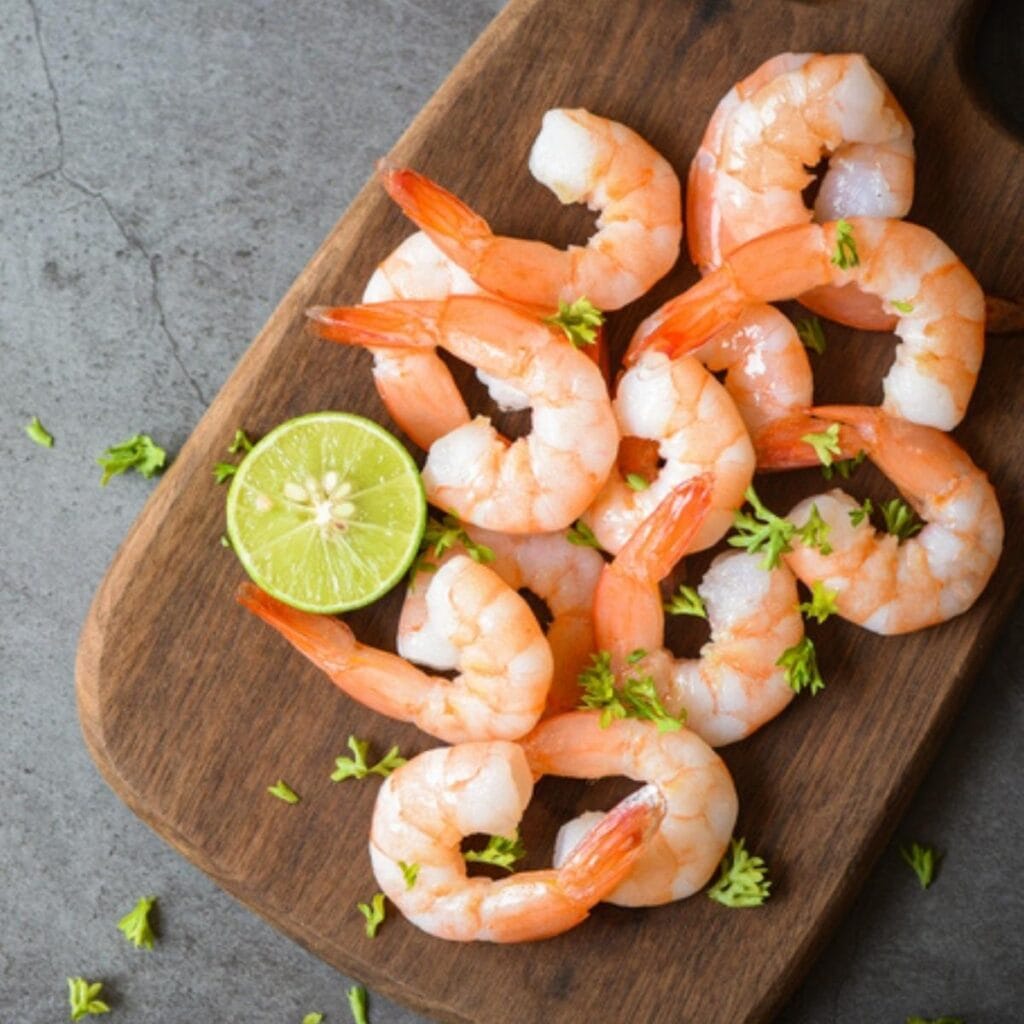 Peeled Boiled Shrimp on a Wooden Chopping Board