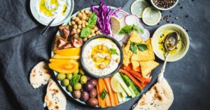 Homemade Hummus Dip with Vegetable Sticks, Chickpeas, Olives, Pita and Chips