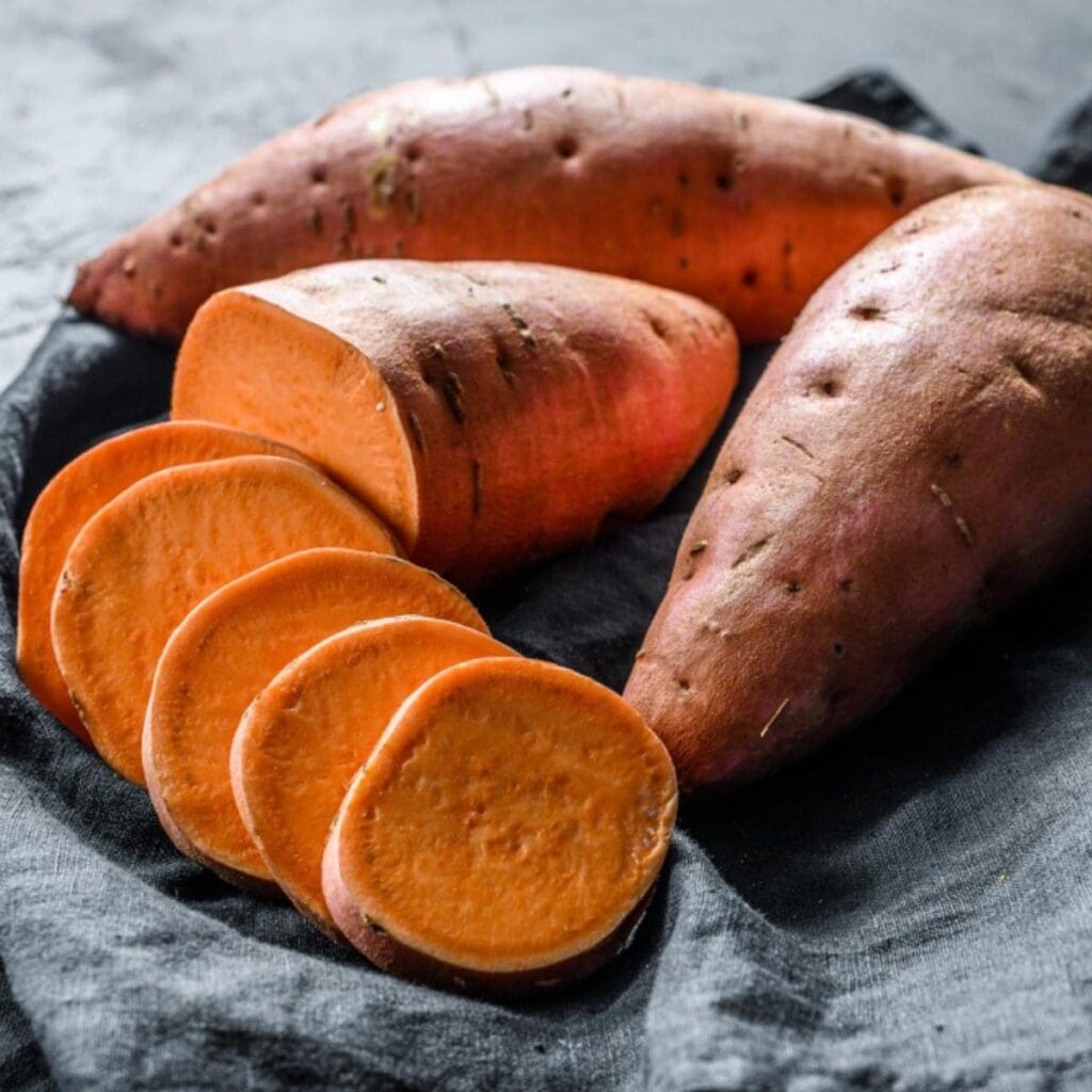 Sweet Potatoes Laid on a Dark Cloth