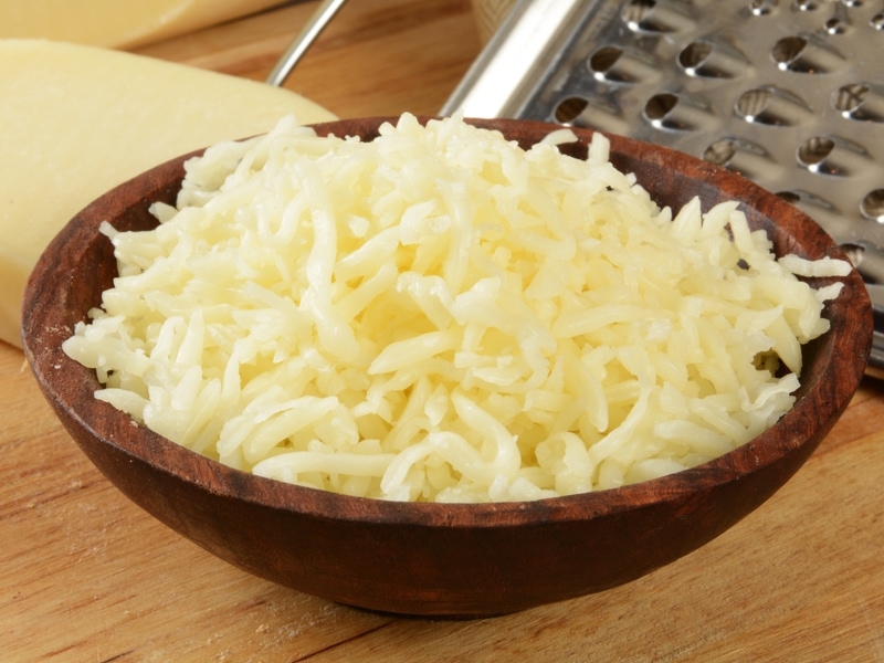 Grated Mozzarella Cheese on a Wooden Bowl