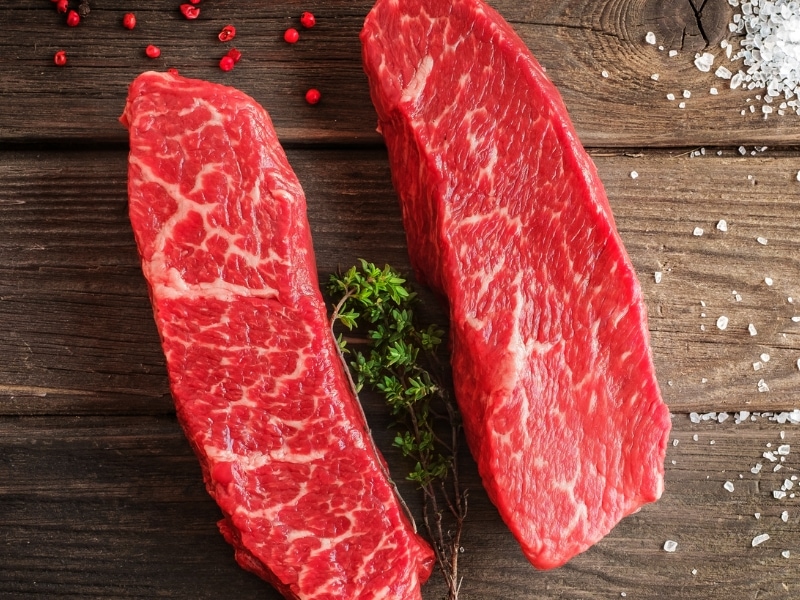 Two Raw Denver Steak on a Wooden Table with Herb and Spices