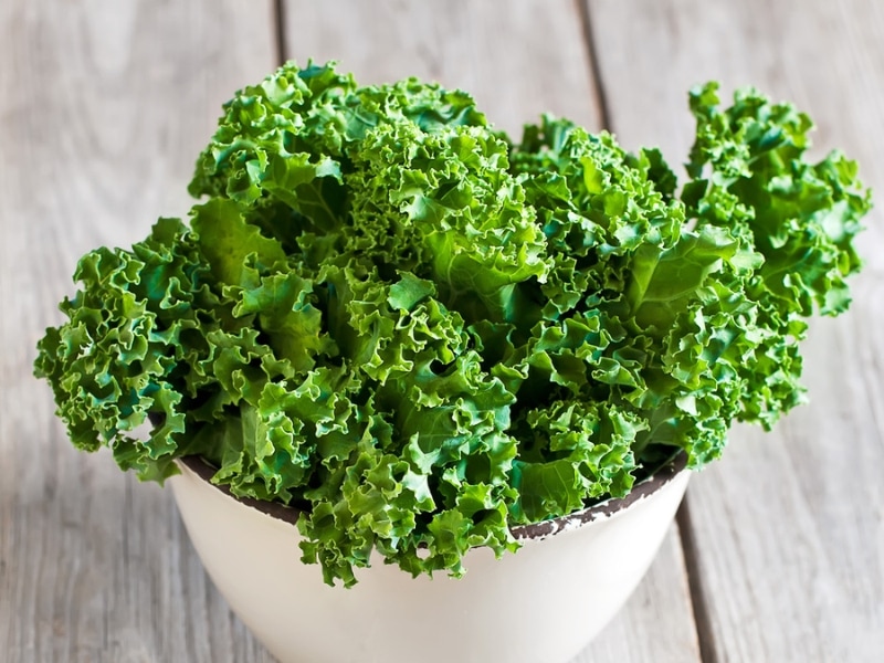 Fresh kale leaves on a ceramic bowl.