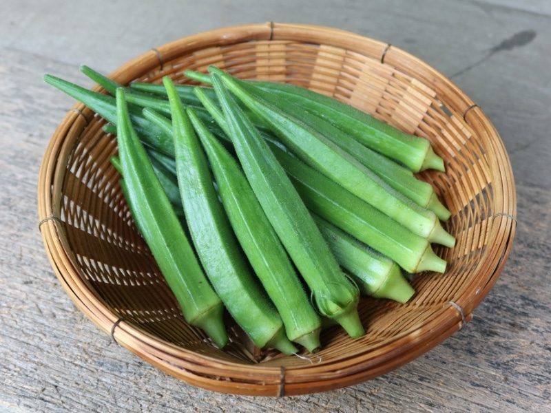 Wooden basket with fresh okra. 