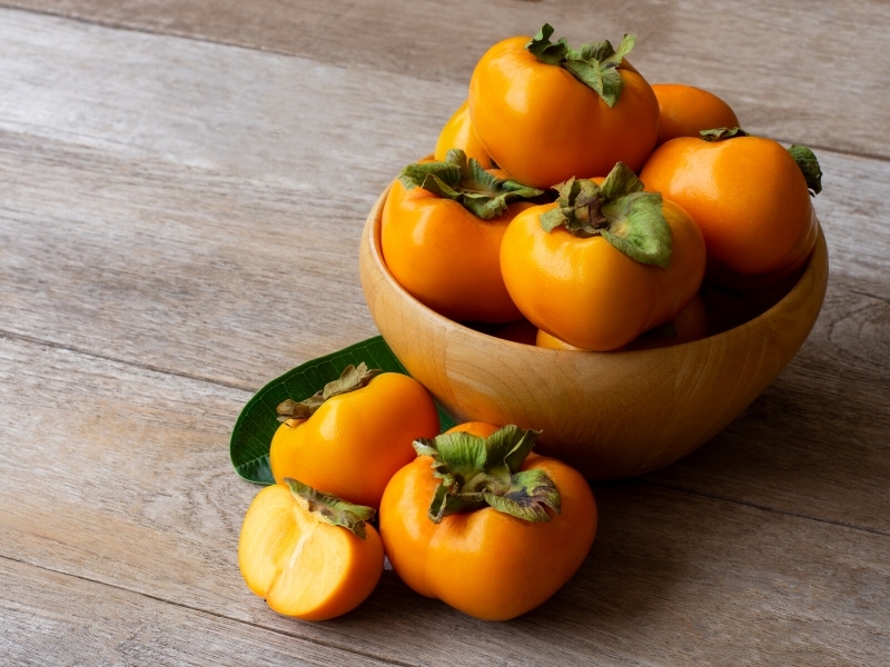 Persimmon on Wooden Bowl
