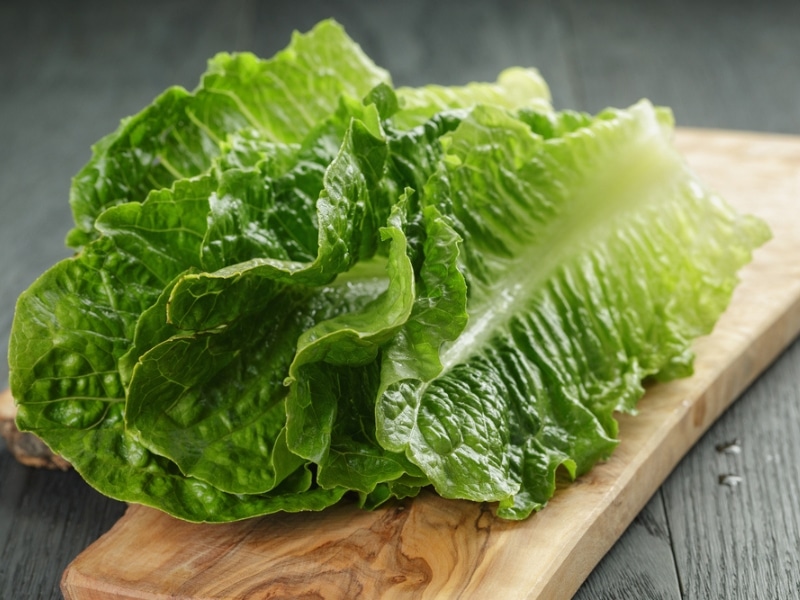 Romaine lettuce on a wooden chopping board. 