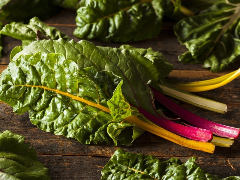 Swiss chard leaves on a wooden table.