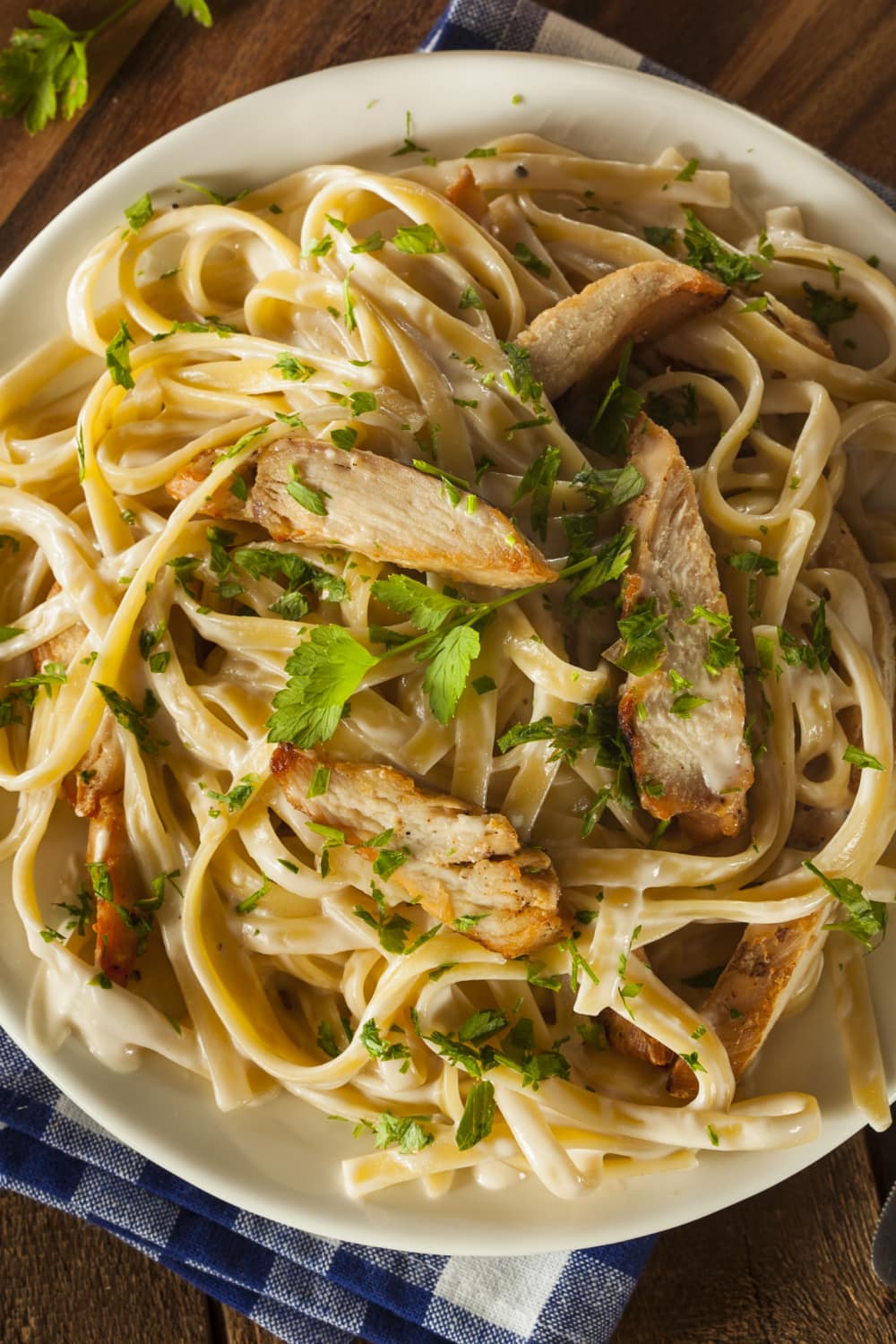 Pasta with chicken alfredo sauce topped with chunks of chicken meat.