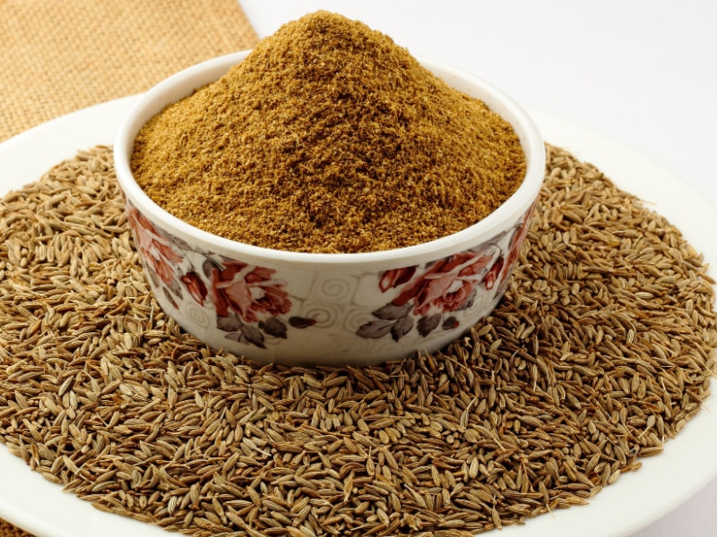 Whole Cumin on a Plate and Cumin Powder in a Bowl