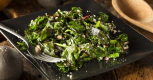 Homemade Sauteed Spinach with Garlic and Cheese in a Black Plate