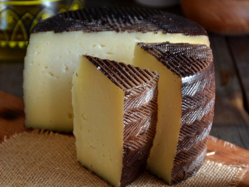 Manchego Cheese on a Rustic Cloth and Cutting Board