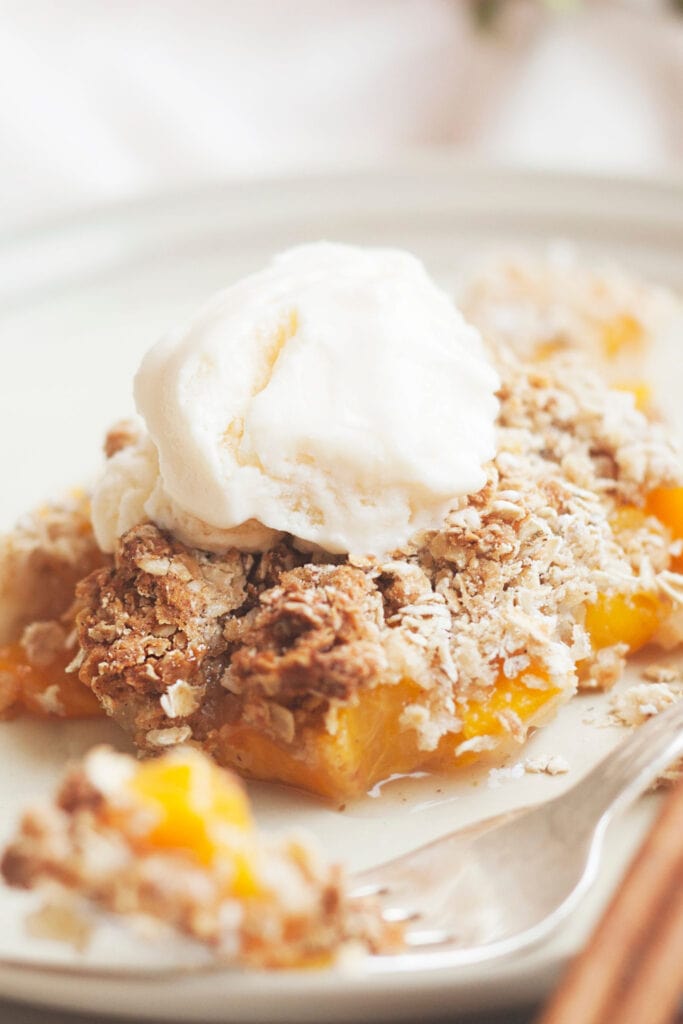 Peach Crisp With Scoop of Vanilla Ice Cream on Top